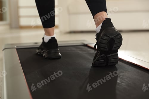 Preview: Sporty woman training on treadmill at home, closeup