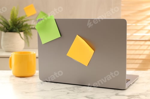 Preview: Modern laptop with sticky notes and cup on white marble desk indoors