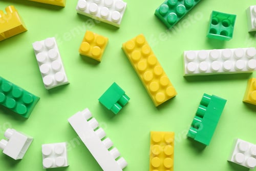 Preview: Building blocks on green background, flat lay. Child's toy