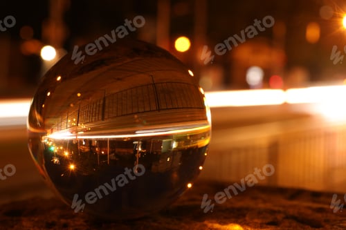 Preview: Beautiful city street, overturned reflection. Crystal ball at night, closeup. Space for text