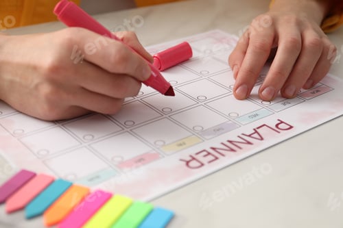 Preview: Woman using planner at white table, closeup