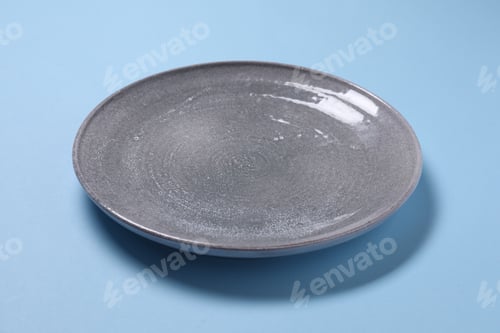 Preview: Empty grey plate on light blue background, closeup
