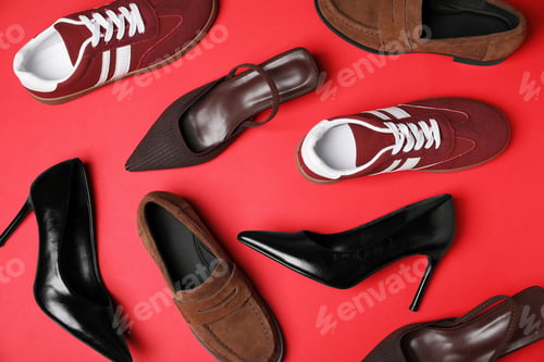 Preview: Different stylish shoes on red background, flat lay