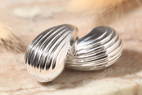 Preview: Beautiful silver earrings on light background, closeup