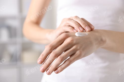 Preview: Woman applying hand cream at home, closeup