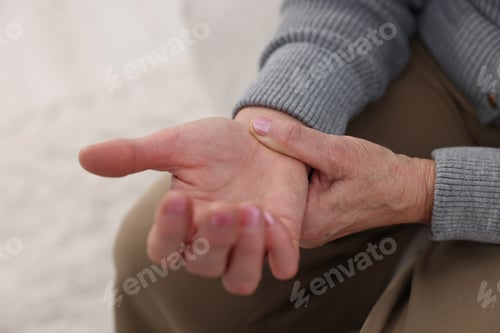 Preview: Senior woman suffering from wrist pain at home, closeup. Rheumatism symptom