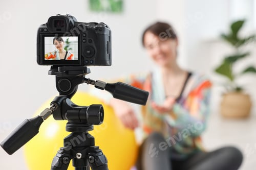 Preview: Happy sports blogger recording fitness lesson at home, focus on camera