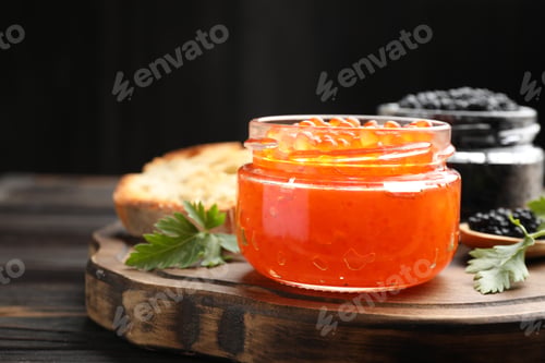 Preview: Delicious red caviar in jar and parsley on wooden table, closeup