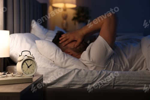 Preview: Man suffering from headache on bed, selective focus