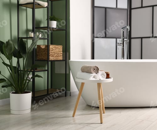 Preview: Tub, folding screen and green houseplant in bathroom. Interior design