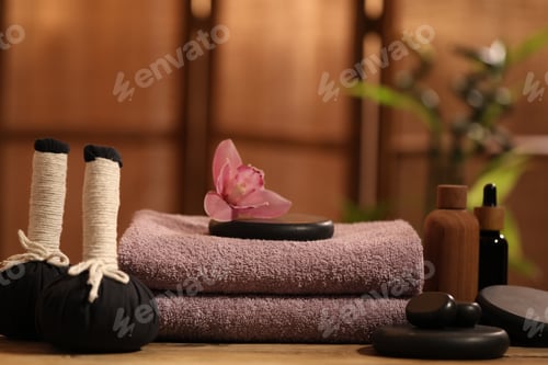 Preview: Spa composition with soft clean towels and herbal bags on wooden table indoors, closeup