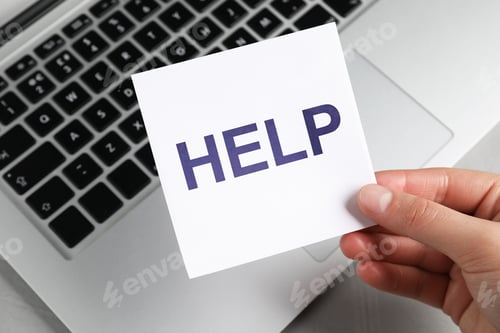 Preview: Woman holding paper note with word Help above laptop, closeup