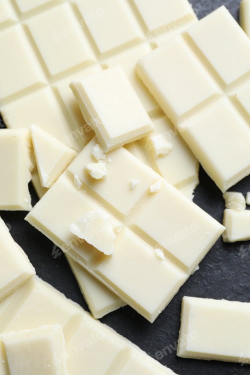Preview: Pieces of white chocolate on grey table, flat lay