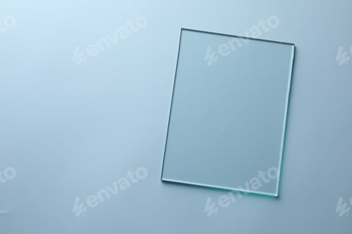 Preview: One clean glass sheet on light blue background, top view. Space for text