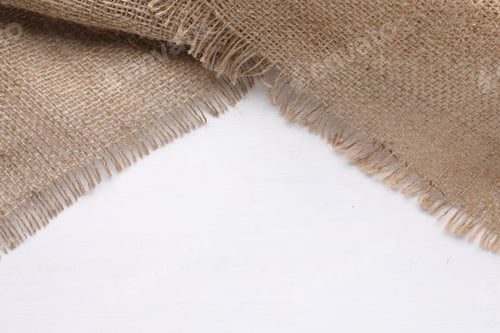 Preview: Natural burlap fabric on white wooden table, top view. Space for text