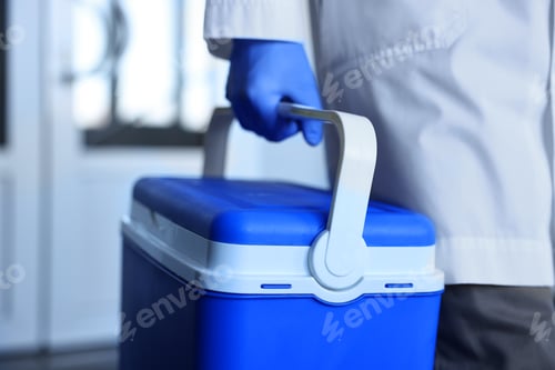 Preview: Laboratory worker holding blue cool box in clinic, closeup
