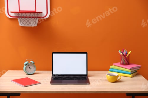Preview: Stylish workplace with laptop, alarm clock, stationery and cup of tea on wooden table indoors
