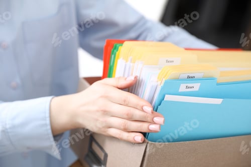 Preview: Tax. Woman with box full of folders in office, closeup