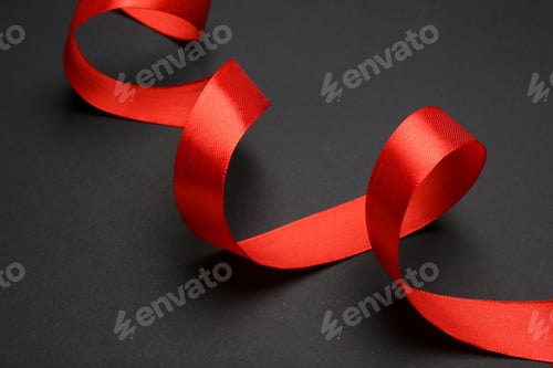 Preview: Beautiful red ribbon on dark background, closeup
