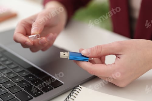 Preview: Woman with USB flash drive at desk, closeup