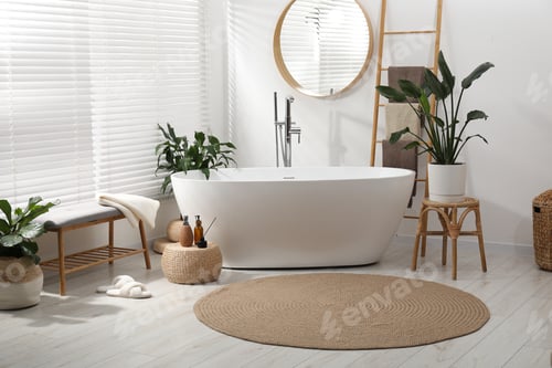 Preview: Stylish round bathroom mat near bathtub on floor indoors. Interior design