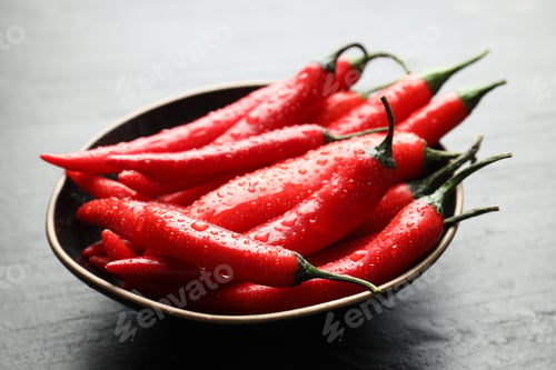 Preview: Ripe red chili peppers in bowl on grey table, closeup