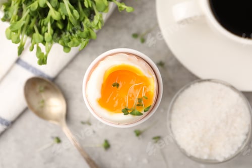Preview: Tasty breakfast with soft boiled egg, microgreens, salt and coffee on grey table, flat lay