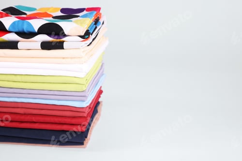 Preview: Stack of colorful bed linens on white background, closeup. Space for text