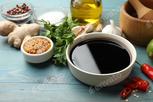 Preview: Soy sauce and other different ingredients for marinade on light blue wooden table, closeup