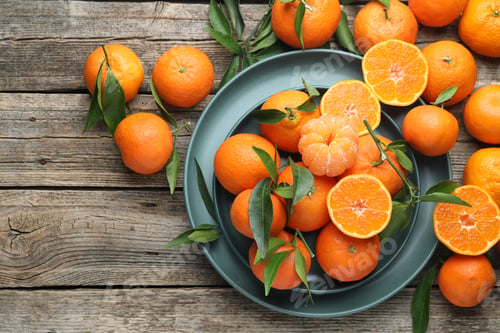Preview: Fresh tangerines and green leaves on wooden table, flat lay. Space for text