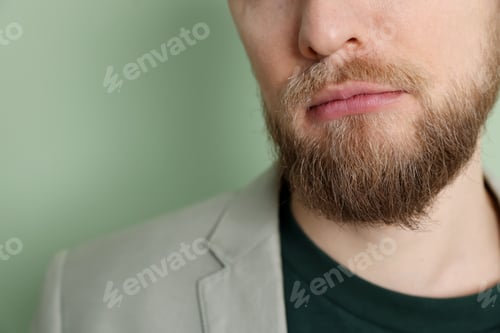 Preview: Resentful man on light green background, closeup. Space for text