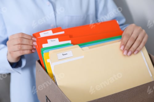 Preview: Tax. Woman looking through office folders in box indoors, closeup
