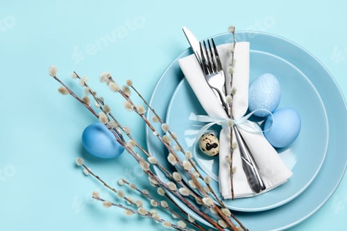 Preview: Easter celebration. Festive table setting with willow branches and painted eggs on light blue backgr