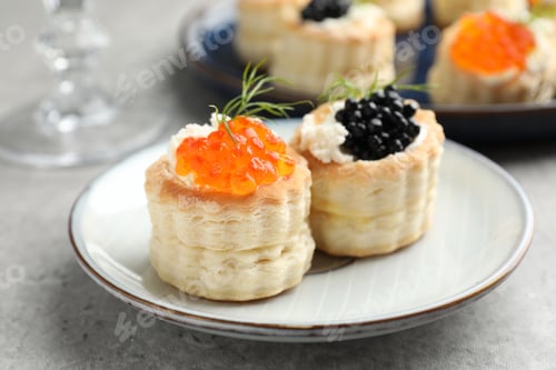Preview: Tasty puff pastries with cream cheese, caviar and dill on grey table, closeup