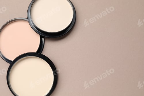 Preview: Face powder of different shades in containers on beige background, flat lay, Space for text