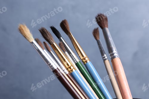 Preview: Different paint brushes on blue background, closeup