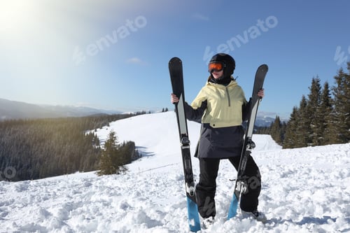 Preview: Skier with skis in mountains on winter day. Space for text