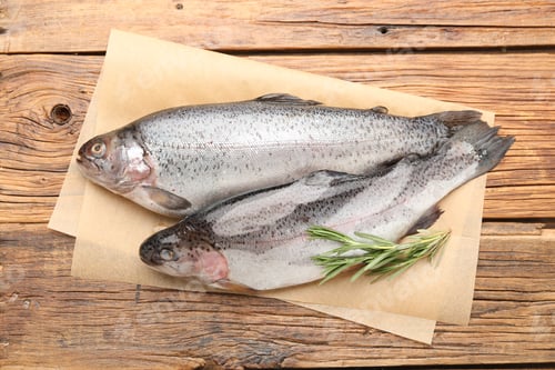 Preview: Raw trout fish and rosemary on wooden table, top view