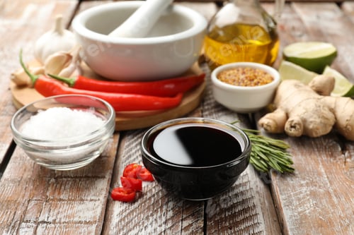 Preview: Soy sauce and other different ingredients for marinade on wooden table, closeup