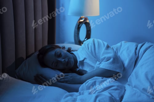 Preview: Woman sleeping with illuminated night lamp at home