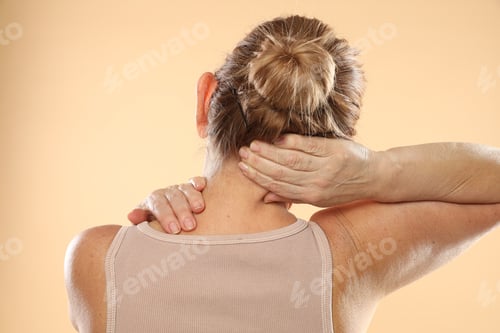 Preview: Woman doing neck massage on beige background, back view