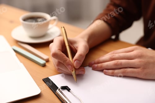 Preview: Woman writing in clipboard with pen at wooden table, closeup