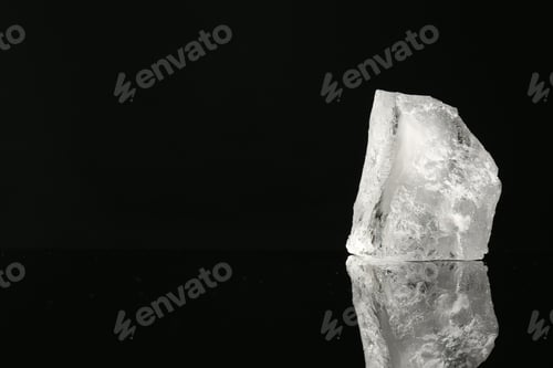 Preview: Piece of clear ice on black mirror surface, space for text