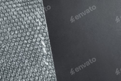 Preview: Transparent bubble wrap on black background, top view. Space for text