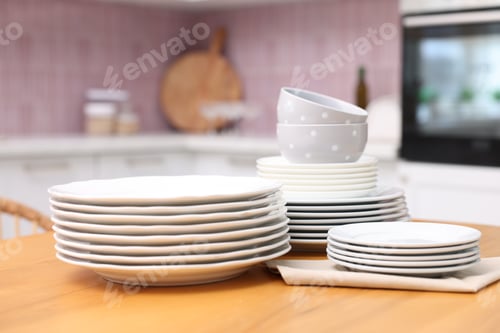 Preview: Set of clean dishes on wooden table in kitchen, closeup