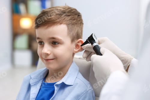 Preview: Hearing test. Doctor examining boy's ear with otoscope in clinic, closeup