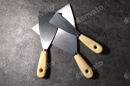 Preview: Putty knives on grey table, flat lay. Construction tool