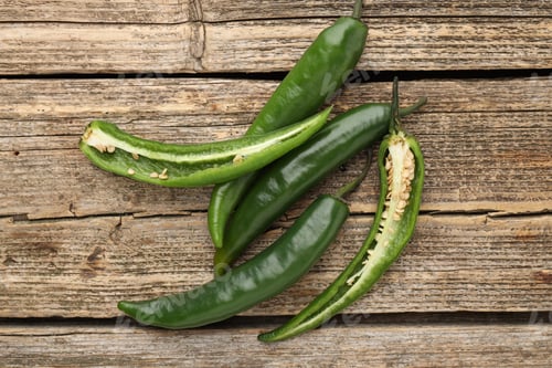 Preview: Fresh green chili peppers on wooden table, top view