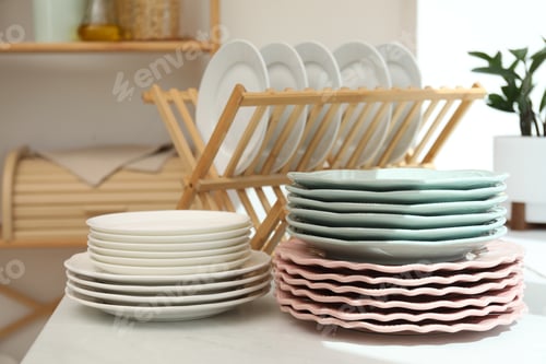 Preview: Set of clean plates on white marble countertop in kitchen, closeup