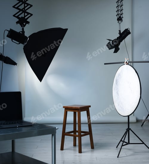 Preview: Professional lighting equipment hanging from ceiling and chair in photo studio